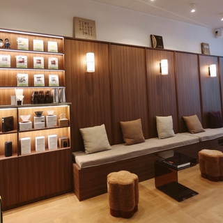 Salon boisé du Coffee UP à Genève, avec banquette, coussins et étagères éclairées